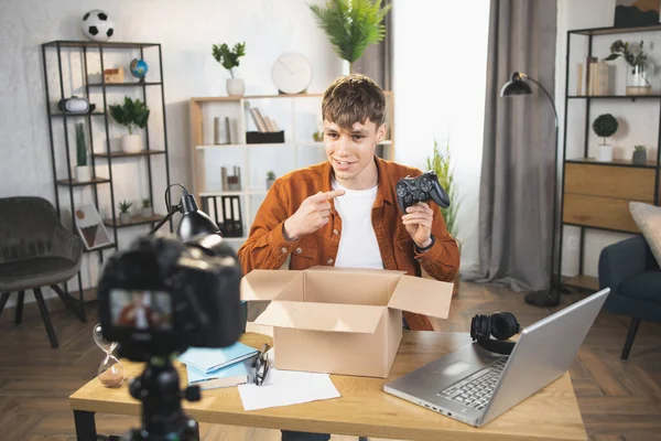 Ο άνθρωπος εγγραφή βίντεο, ενώ αποσυσκευασία κουτί με joystick — Φωτογραφία Αρχείου