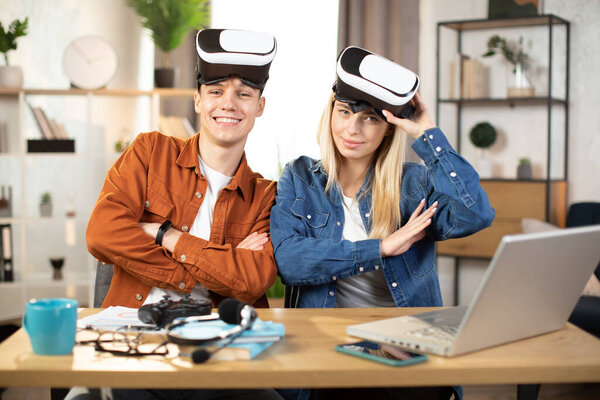 Young couple using VR headset and laptop for playing games