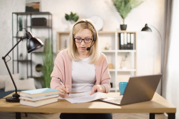 Mooie vrouwelijke software ontwikkelaar met behulp van moderne laptop voor werk op afstand thuis. — Stockfoto