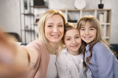 Küçük çocuklar anneleriyle cep telefonunda selfie çekiyorlar, evde aile hafta sonunun tadını çıkarıyorlar..