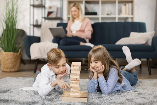 Küçük çocuklar, ahşap yapı taşları ile bir kule inşa ederek oyun oynarlar. — Stok fotoğraf
