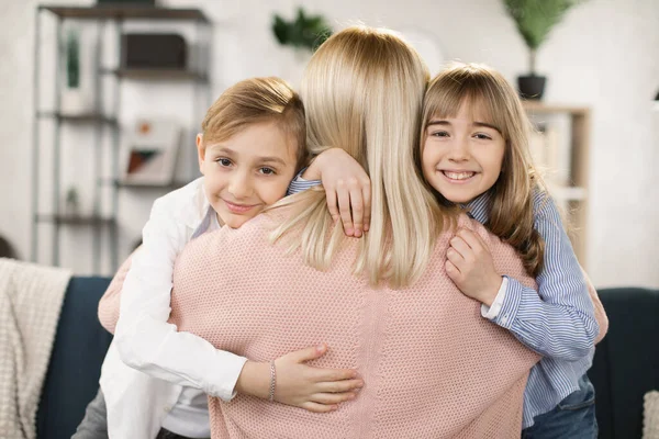 Mutlu, sevgi dolu bir aile annesi ve iki küçük tatlı çocuk kucaklaşıp kameraya bakıyor. — Stok fotoğraf