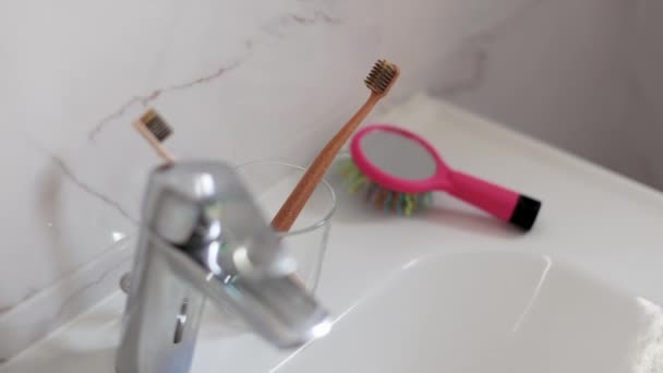 Madre y su hija tomando cepillos de dientes de un vaso antes de cepillarse los dientes en el baño — Vídeos de Stock