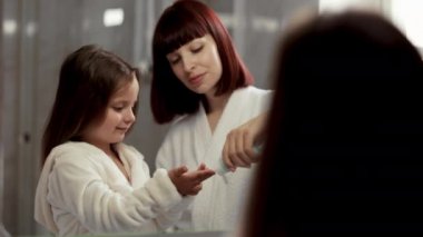 Çocuk yanaklarına nemlendirici sürüyor..