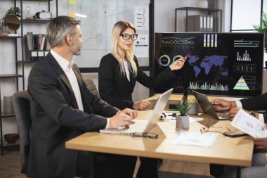 Arkaplanda harita ve çizelgeler olan TV ekranı.