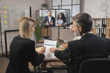 Deneyimli çok ırklı iş insanlarının mali raporları analiz ederken yakın plan çekimleri