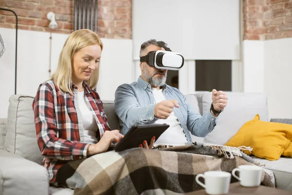 Famille de personnes matures utilisant des lunettes VR et une tablette à la maison — Photo