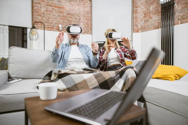 Felnőtt férj feleséggel szórakozás kanapén VR headsetek — Stock Fotó