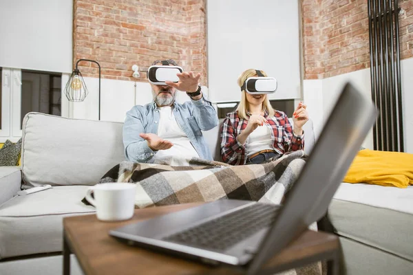 Felnőtt férj feleséggel szórakozás kanapén VR headsetek — Stock Fotó