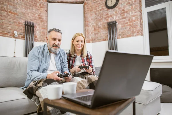 Cheerful mature couple playing video games at home — Foto de Stock