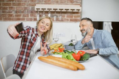 Neşeli aile ev mutfağında selfie çekiyor.