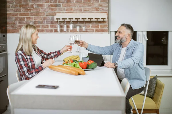 Couple drinking water and eating vegetables on kitchen — Stock Fotó