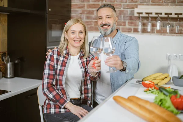 Mature couple sitting on kitchen with glasses of fresh water — Stock Fotó