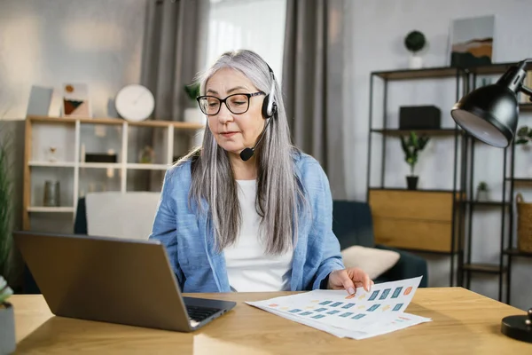 Χαρούμενη ώριμη γυναίκα που παρουσιάζει οικονομική έκθεση στους συναδέλφους μέσω βιντεοκλήσης στο laptop. — Φωτογραφία Αρχείου
