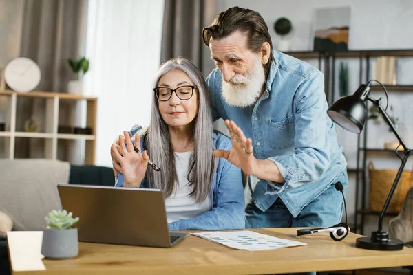 Aydınlık bir evde gündelik giysiler içinde modern aletlerle poz veren pozitif kıdemli karı ve koca..
