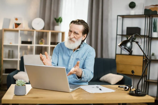 Χαμογελώντας ώριμος επιχειρηματίας χρησιμοποιώντας σύγχρονο φορητό υπολογιστή για συνομιλία βίντεο σε απομακρυσμένη εργασία. — Φωτογραφία Αρχείου