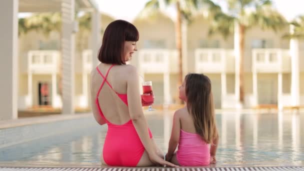 Back view of happy mother and her daughter look at each other and waving their hands to camera — Stockvideo
