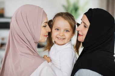 Üç dişi Arap neslini sevmenin arka planda kalan görüntüsü, tatlı şefkat duygularını gösteriyor.