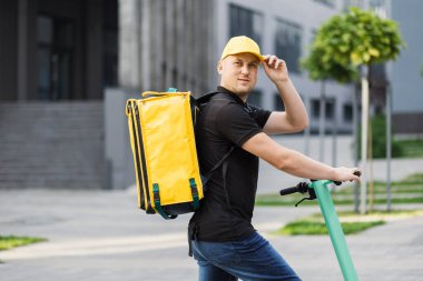 Teslimatçı taze yiyecek getiriyor, elektrikli scooterla hızlı gidiyor..