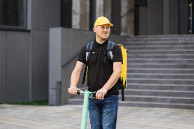 Teslimatçı taze yiyecek getiriyor, elektrikli scooterla hızlı gidiyor..