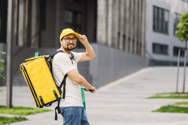 Motosikletli bir erkek kurye. Sıcak yemek teslimatı var. Paketler ve restoranlardan eve.