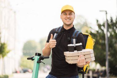Akıllı telefondan konuşan şapkalı teslimatçı..