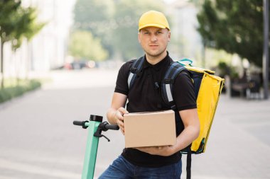 Karton kutu taşıyan teslimatçı..