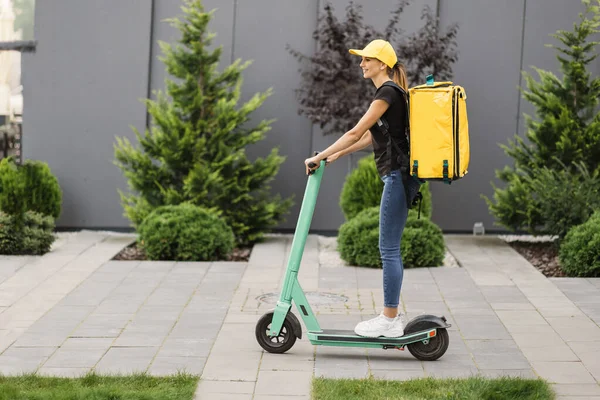 Bezorging vrouw paardrijden scooter in grote moderne stad. — Stockfoto