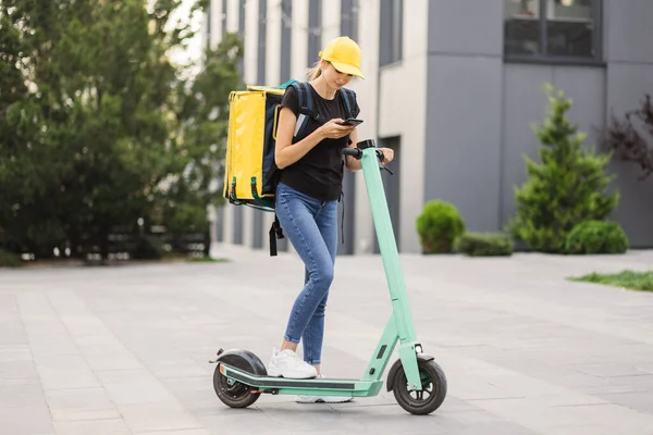 Food delivery woman with thermo backpack κρατώντας το κινητό τηλέφωνο περιμένει επόμενη παραγγελία. — Φωτογραφία Αρχείου