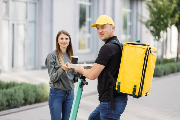 Elektrikli scooter kullanan kurye servis çalışanı müşteriye yemek dağıtıyor, internetten şehir kargo siparişi veriyor..