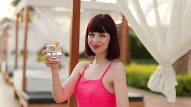 Attractive calm pretty woman in trendy pink swimsuit with fresh cool drink — Stock Video