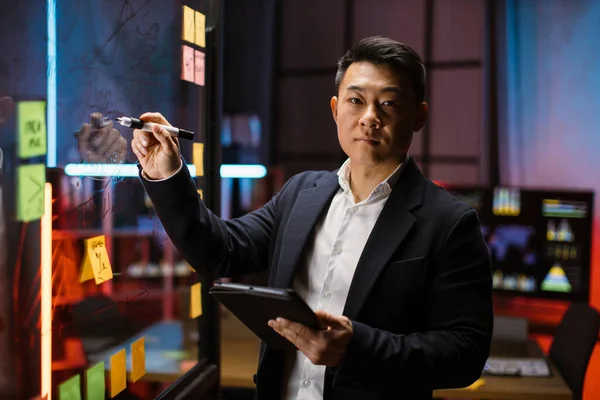 Focado inteligente empresário asiático, desenhar gráficos em placa de apresentação de vidro. — Fotografia de Stock