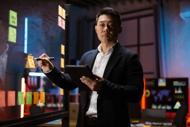 Ofisteki cam tahtada Asyalı iş adamı projesi