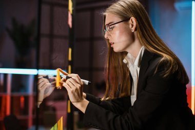 Ofiste çalışan kadın itiş kakış ustası yapışkan nota sürat ödevi yazıyor.