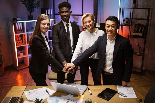 Πολυεθνικοί εταιρικοί συνεργάτες στη συνεδρίαση του γραφείου, στέκονται στο τραπέζι και στοιβάζουν τα χέρια — Φωτογραφία Αρχείου