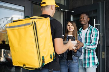 Delivery man with yellow uniform and cap that new normal style by express service
