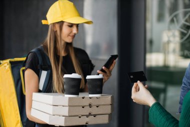 Genç bayan kuryenin görüntüsü müşteriye sipariş veriyor..