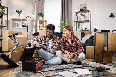 Alet çantalı çok kültürlü bir çift yeni evinde oturuyor.