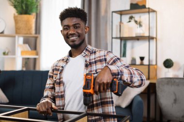 Evde mobilya montajı yapan genç adamın portresi