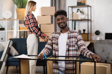 Yeni evinde kutuları ve aletleri olan genç bir çift.