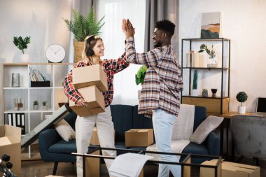 Diverse couple making high five gesture at new flat