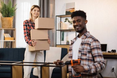 Couple assembling furniture and unpacking boxes at home