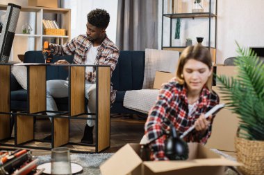 Yeni evinde kutuları ve mobilyaları olan çok kültürlü bir aile.