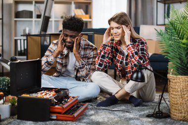 Çok ırklı aile yeni evinde mobilya montajı yapıyor.