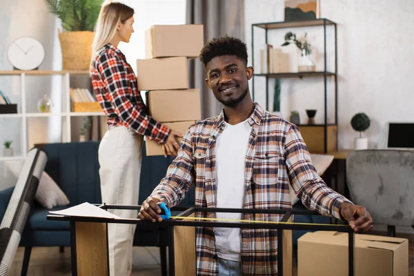 Yeni evinde kutuları ve aletleri olan genç bir çift.