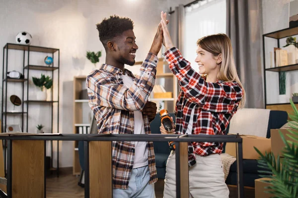 Happy diverse couple giving high five at their new flat — Stock Fotó