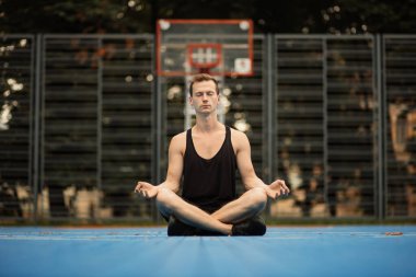 Şehirde yoga yapan genç bir sporcu..