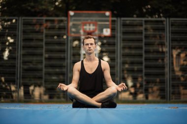 Şehirde yoga yapan genç bir sporcu..