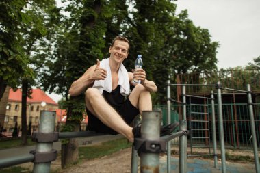 Atletik vücut şekli, adam spor salonunda rahatlıyor..