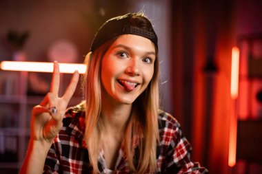 Mesafe çalışması ve öğrenme. Siyah şapkalı ve laptoplu beyaz kız öğrenci video sohbeti için evde ders çalışıyor. Masada oturan ve dizüstü bilgisayarda yazan serbest çalışan bir kadın..